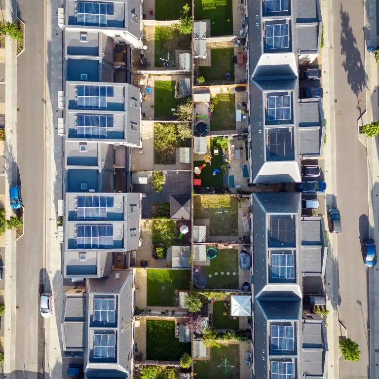 birds eye view of residential area with solar panels on home roofs