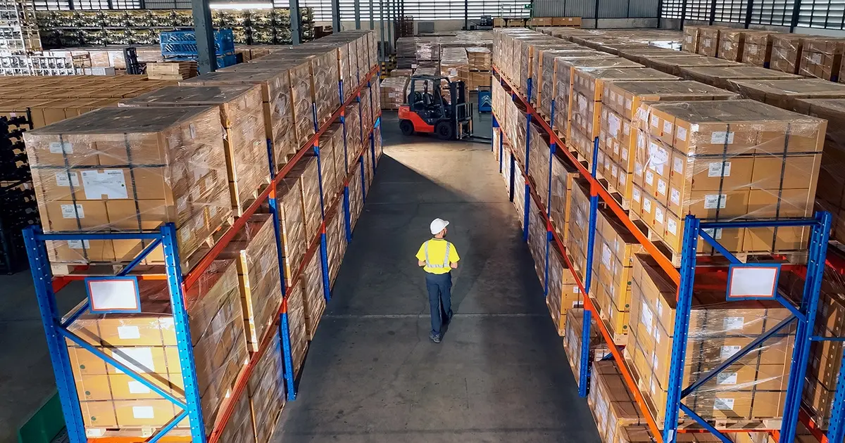 man in reflective gear walking in warehouse